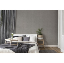 Schlafzimmer mit Bett, Nachttisch und grauer Tapete