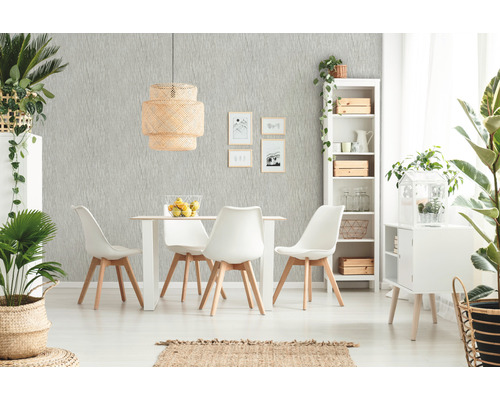 Helles Esszimmer mit Esstisch, Stühlen, Rattanlampe und dekorativen Pflanzen