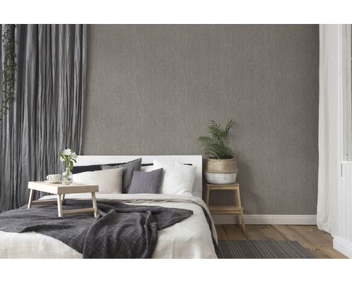 Schlafzimmer mit gemusterter Tapete, Bett und Vorhängen für eine gemütliche Atmosphäre