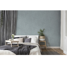 Schlafzimmer mit Bett und Wandtapete mit Pflanzenmuster