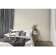 Helles Schlafzimmer mit Bett, Kissen, Decke, Vorhängen und Zimmerpflanze für eine gemütliche Atmosphäre