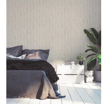 Schlafzimmer mit Bett, Nachttisch und Zimmerpflanzen vor einer Strukturtapete