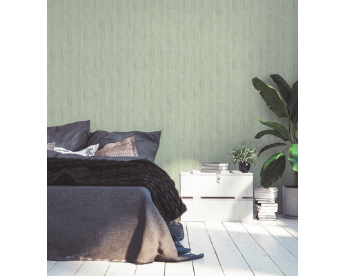 Schlafzimmer mit Bett, Nachttisch, Zimmerpflanzen und grüner Tapete