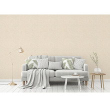 Wohnzimmer mit einer strukturierten Tapete in einer hellen Farbe, einem Sofa, einem Tisch und einer Stehlampe.