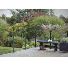 Scène de terrasse avec garde-corps en verre, banc et plantations dans le jardin