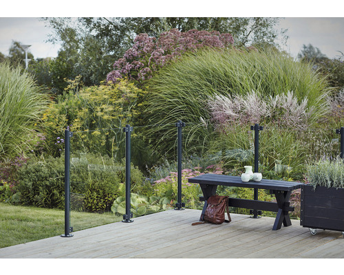 Scène de terrasse avec garde-corps en verre, banc et plantations dans le jardin