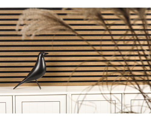 Dekoratives Wandpaneel mit einer schwarzen Vogelstatue auf einem Schrank
