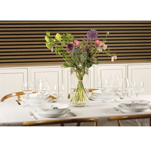Gedeckter Esstisch mit Blumen in Vase und Geschirr