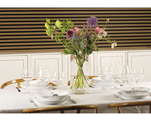 Gedeckter Esstisch mit Blumen in Vase und Geschirr