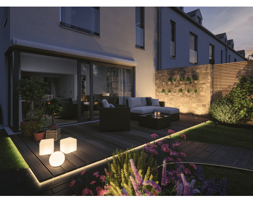 Beleuchtete Terrasse mit Gartenmöbeln, Pflanzen und dekorativer Beleuchtung für den Aussenbereich