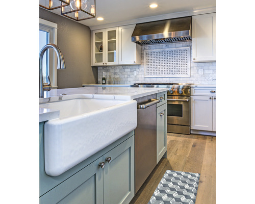 Küchenszene mit Spüle, Herd und Dunstabzugshaube in einem hellen, organisierten Raum