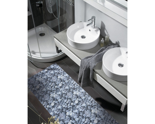 Salle de bains avec deux lavabos, douche et tapis de bain avec motif de pierre