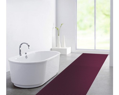 Salle de bain avec baignoire îlot, robinetterie et tapis de bain