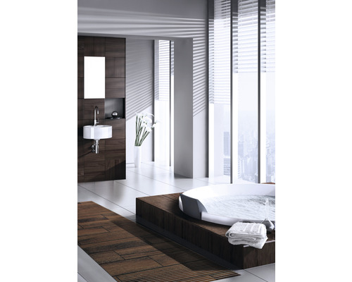 Helles Badezimmer mit Badewanne auf Holzpodest, Waschbecken, Spiegel und Holzvertäfelung