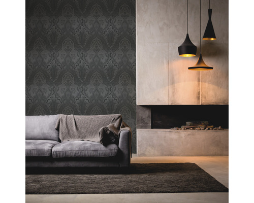 Salon avec papier peint à motifs, canapé, tapis et suspensions