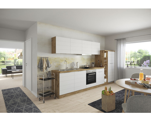 Cuisine claire avec armoires blanches et plan de travail en bois, coin repas et vue sur un salon