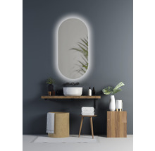 Salle de bain moderne avec miroir ovale et éclairage, lavabo avec vasque à poser et éléments en bois pour une ambiance claire et organisée.