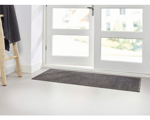Paillasson gris devant une porte blanche avec fenêtre