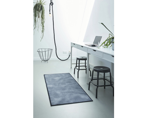 Pièce lumineuse avec bureau, chaises, lampe et tapis rectangulaire