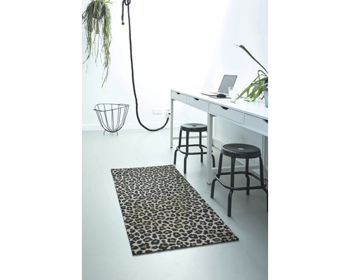Vue d''ensemble d''une pièce avec un tapis à motif animalier, un bureau et des décorations