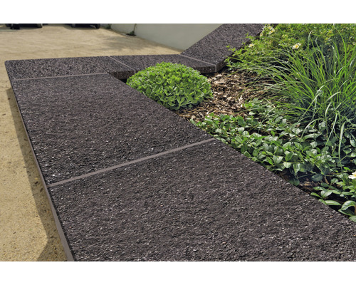 Gartengestaltung mit Beetbegrenzung aus dunklem Material und Pflanzen