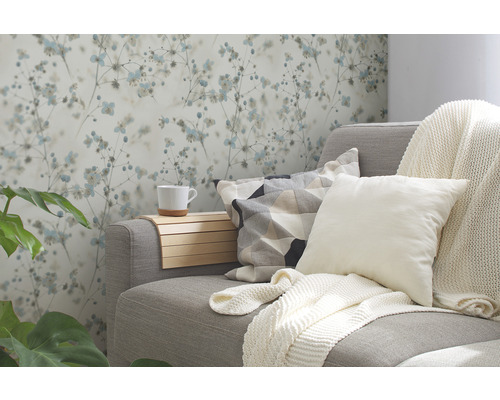 Wohnzimmer mit gemusterter Tapete, Sofa, Kissen und Getränkehalter