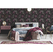 Schlafzimmer mit floraler Tapete, Bett und Nachttischen.