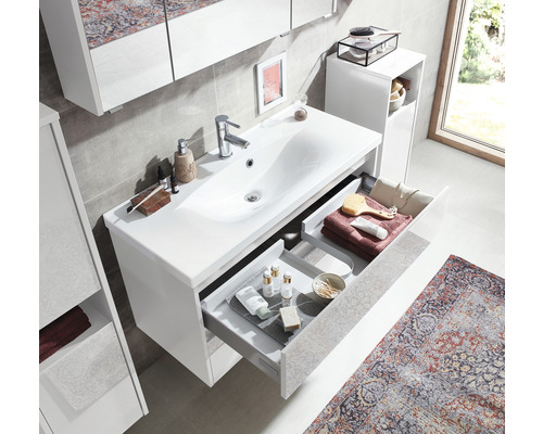 Helles Badezimmer mit Waschbeckenunterschrank, offenem Schubladensystem und Badutensilien.