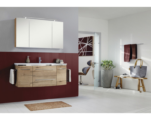 Salle de bain lumineuse avec meuble-lavabo, armoire de toilette et décorations pour une atmosphère conviviale.