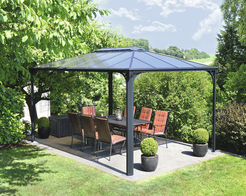 Pavillon avec table et chaises dans le jardin.