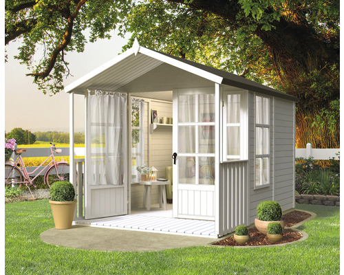 Maison de jardin en bois avec fenêtres et rideaux dans le jardin