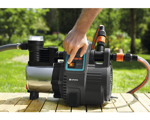 Gartenpumpe mit digitaler Anzeige und angeschlossenem Schlauch im Außenbereich