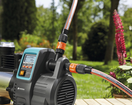 Gartenpumpe mit angeschlossenen Gartenschläuchen im Aussenbereich