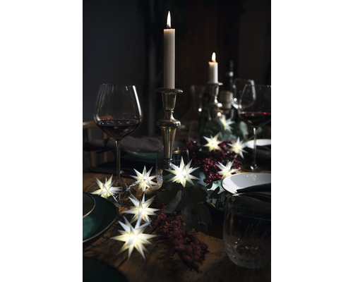 Table festive avec bougies, guirlande lumineuse en forme d''étoile, verres et décoration