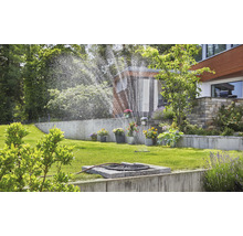 Arrosage de jardin avec arroseur de gazon dans un jardin verdoyant