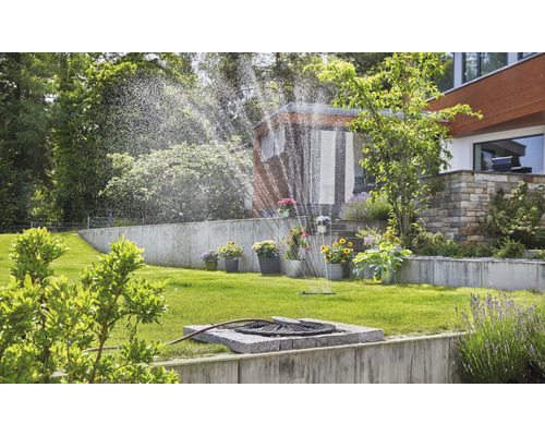 Arrosage de jardin avec arroseur de gazon dans un jardin verdoyant