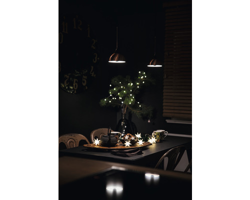 Festlich gedeckter Esstisch mit Teekanne, Tassen, Sternenlichterkette und Dekoration für eine gemütliche Atmosphäre