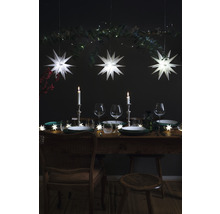 Festlich gedeckter Tisch mit Sternenlichtern, Kerzen und Weingläsern für eine elegante Atmosphäre