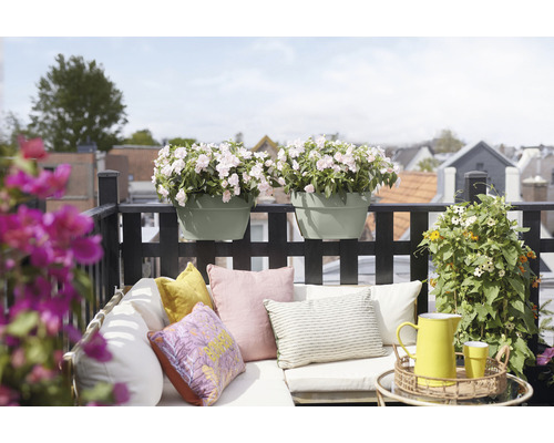 Dekorierter Balkon mit Blumenkästen, Kissen und Gartenmöbeln für eine gemütliche Atmosphäre