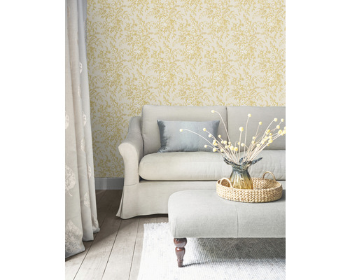 Wohnzimmer mit Sofa, Hocker und floral gemusterter Tapete