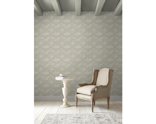 Heller Raum mit floral gemusterter Tapete, Sessel und kleinem Tisch