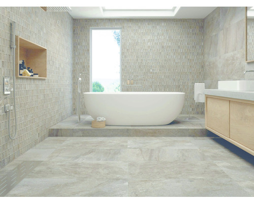 Helles Badezimmer mit freistehender Badewanne, Waschtisch und Mosaikfliesen