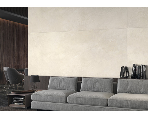 Beige Wandfliesen über einem grauen Sofa in einem Wohnzimmer