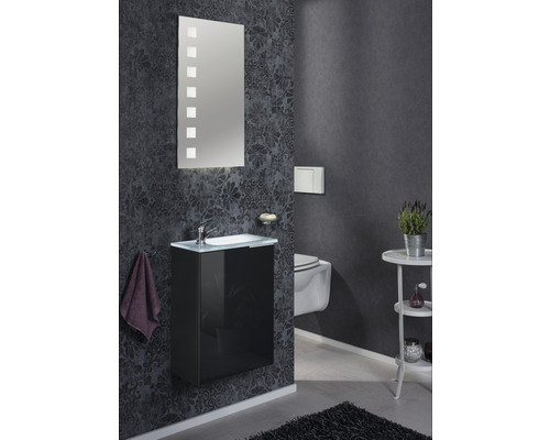 Salle de bains avec lavabo, miroir et toilettes sur mur sombre