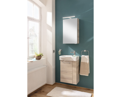 Salle de bain lumineuse avec meuble-lavabo, armoire de toilette et porte-serviettes