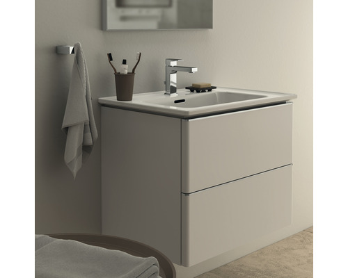 Meuble-lavabo avec meuble sous-vasque, robinetterie, serviette et accessoires de salle de bain dans une salle de bain