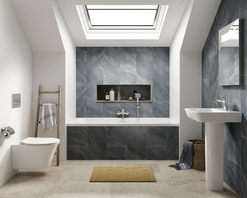Salle de bains moderne avec toilettes, lavabo, baignoire et fenêtre de toit