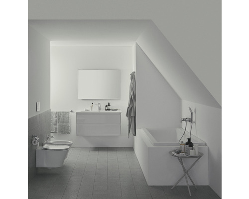 Salle de bains avec toilettes, bidet, lavabo, miroir et baignoire dans un espace mansardé