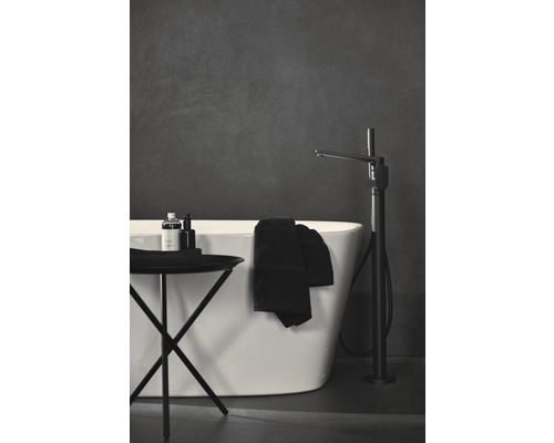 Salle de bains avec baignoire, robinet et table d''appoint