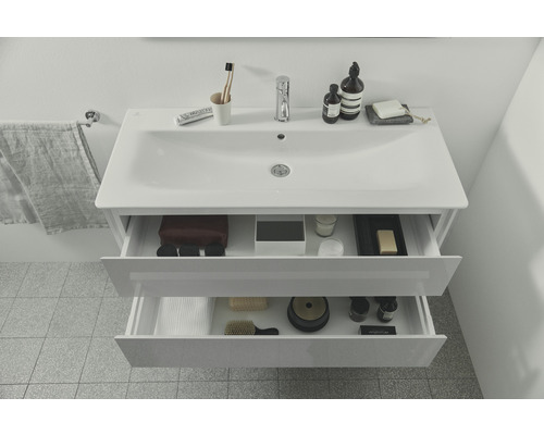 Meuble sous-vasque avec deux tiroirs ouverts dans une salle de bain.